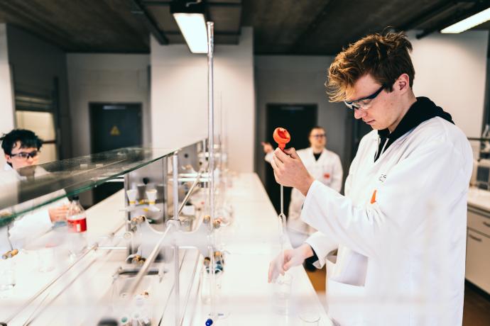 Studenten chemie op campus geel aan het werk in het labo