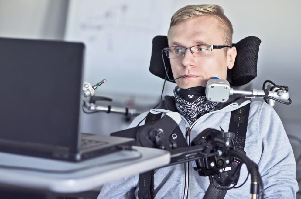 Persoon in rolstoel met elektronische toestellen rondom hem