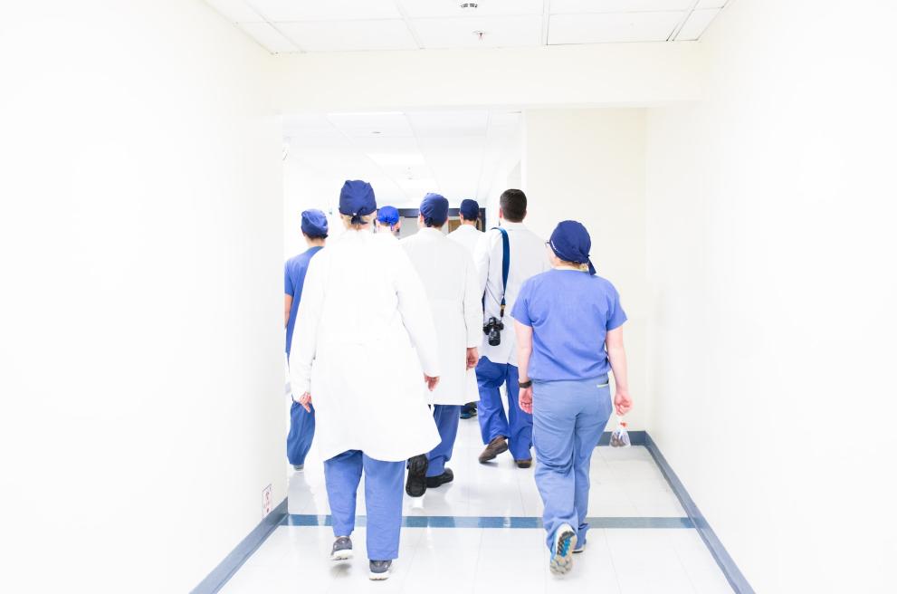 Groep verpleegkundigen die door de gangen van een ziekhuis stapt